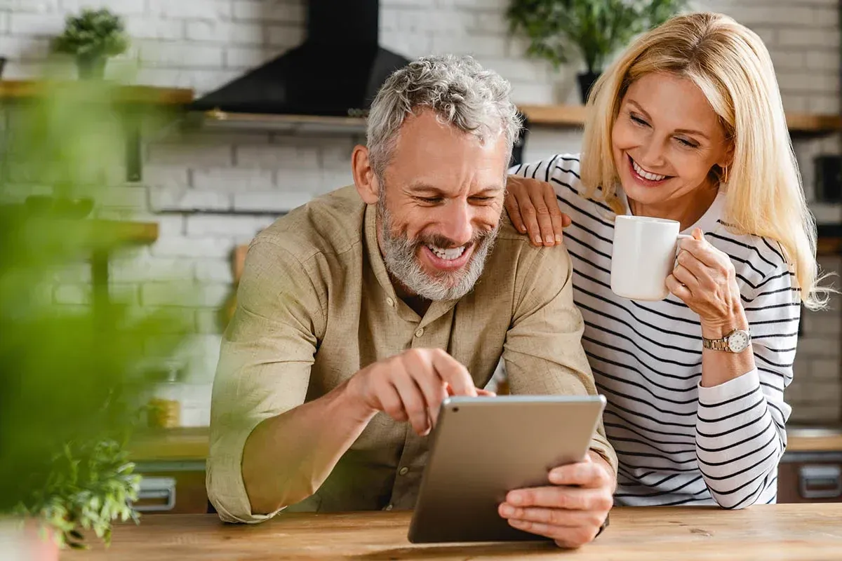 A couple reviewing their progress together on a tablet at home
